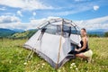 Woman tourist hiking in mountain trail, enjoying summer sunny morning in mountains near tent Royalty Free Stock Photo