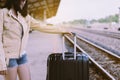 Woman tourist holding suitcase and waiting at train station,Travel and vacation concept,Happy and free time,Close up