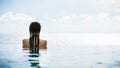 Woman tourist in infinity pool of hotel resort at ocean Royalty Free Stock Photo