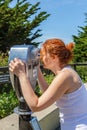 Woman looking at skyline through Coin operated binoculars or telescope. Royalty Free Stock Photo