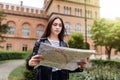 Young woman tourist looking at the map on the street of european city, travel to Europe Royalty Free Stock Photo