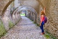 Woman tourist looking throw an archway with multiple arches, paved with cobblestone, in Biertan fortified church, Transylvania Royalty Free Stock Photo