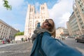 Woman tourist makes a photo about Brussels Cathedral or Saint Michel et Gudula Cathedral in Brussels, Belgium