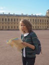 Woman tourist with map on the street. Travel guide, tourism in Europe. The ancient city of Gatchina. Royalty Free Stock Photo