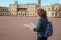 Woman tourist with map on the street. Travel guide, tourism in Europe. The ancient city of Gatchina. Royalty Free Stock Photo