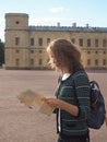 Woman tourist with map on the street. Travel guide, tourism in Europe. The ancient city of Gatchina. Royalty Free Stock Photo