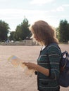 Woman tourist with map on the street. Travel guide, tourism in Europe. The ancient city of Gatchina. Royalty Free Stock Photo