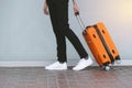 Woman tourist with orange suitcase at station background. travel, tourist, vacation concept