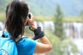 Woman tourist/photographer taking photo with digital camera in jiuzhaigou Royalty Free Stock Photo