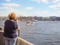 Woman tourist photographing the sights and sailing ships on the river in the summer. Saint-Petersburg. The River Neva.