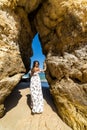 A woman tourist poses on the Praia do Camilo beach of Lagos, Portugal. Algarve region.