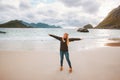 Woman tourist raised hands enjoying ocean view walking on sandy Haukland beach travel in Norway active vacations outdoor