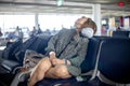 Tourist wait for flight and feel tired sleep on the chair
