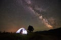 Woman tourist resting at night camping under starry sky and Milky way