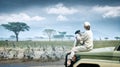 Woman tourist on safari in Africa, traveling by car in Kenya and Tanzania, watching zebras and antelopes in the savannah