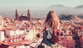 Woman tourist sitting and looking at panoramic view of Jaen city