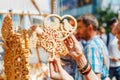 Tourist at a souvenir fair choosing handmade decorative woodcarving gifts