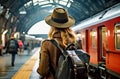 A woman tourist stands at the station near the train in a hat with a backpack. Rear view. Railway station. Journey Royalty Free Stock Photo