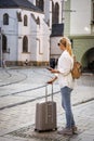 Woman tourist with suitcase waiting for tram on street Royalty Free Stock Photo