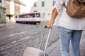 Woman tourist with suitcase waiting for tram on street Royalty Free Stock Photo