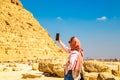 Woman tourist takes photographs of the Pyramid of Khafre