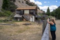 Woman tourist takes photos with a phone of the abandoned buildings in the Bayhorse Ghost Town in Idaho Royalty Free Stock Photo