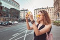 Woman tourist taking pictures by her smartphone while travelling in old European town Royalty Free Stock Photo