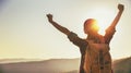 Woman tourist at top of mountain at sunset outdoors during hike