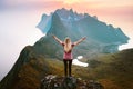 Woman tourist traveling in Norway girl raised hands hiking solo in mountains summer vacations healthy lifestyle