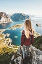 Woman tourist traveling in Norway standing on cliff