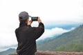 Woman tourist using smartphone taking nature photo of mountain landscape