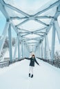 Woman tourist Visiting in Biei, Traveler in Sweater sightseeing Shirahige Waterfall bridge with Snow in winter. landmark and