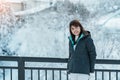 Woman tourist Visiting in Biei, Traveler in Sweater sightseeing Shirahige Waterfall bridge with Snow in winter. landmark and