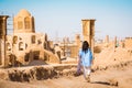 Woman tourist walk on rooftops with panorama from Historic castle in Kashan with city buildings background. Explore iran