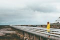 Woman tourist walking alone on bridge Travel Lifestyle emotional concept vacations outdoor yellow raincoat clothing foggy mountain Royalty Free Stock Photo