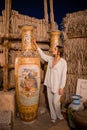 Woman tourist walking in Arab market near Al Seef with crockery, lamps and lanterns in the old style