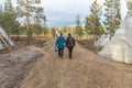 Woman tourist is walking with sami man. saami village on the Kola Peninsula, Russia Royalty Free Stock Photo