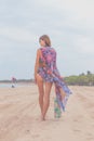 Woman tourist walking on a tropical summer vacation beach wearing sunglasses and beach bag relaxing on travel holidays Royalty Free Stock Photo