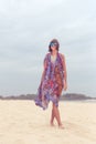 Woman tourist walking on a tropical summer vacation beach wearing sunglasses and beach bag relaxing on travel holidays Royalty Free Stock Photo