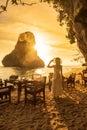 Woman tourist in white dress dinner in restaurant cave on Phra nang Beach at sunset, Railay, Krabi, Thailand. vacation, travel,