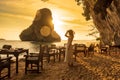 Woman tourist in white dress dinner in restaurant cave on Phra nang Beach at sunset, Railay, Krabi, Thailand. vacation, travel,