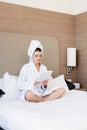 Woman in towel and bathrobe using