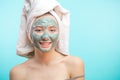 Woman with towel on head applying Facial clay Mask. Royalty Free Stock Photo