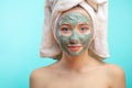 Woman with towel on head applying Facial clay Mask. Royalty Free Stock Photo