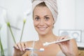 woman with towel on head going to brush teeth