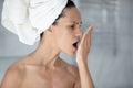 Woman with towel on head opens mouth check breath Royalty Free Stock Photo