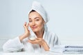 Woman in turban smiling, applying face cream at bathroom Royalty Free Stock Photo