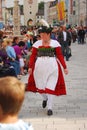 Woman in tpyical bavarian dress walks past people