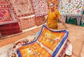 Woman trading an antique carpets and blankets for home during the market day in indian town