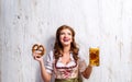 Woman in traditional bavarian dress holding beer and pretzel Royalty Free Stock Photo